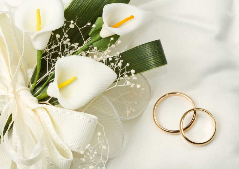 白色鲜花和金色结婚对戒