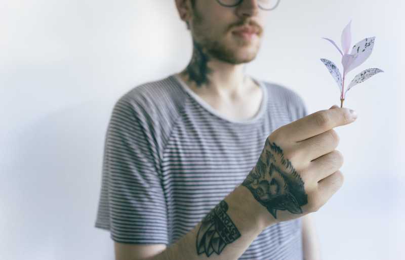 年轻人纹身的男人手上拿着一枝花