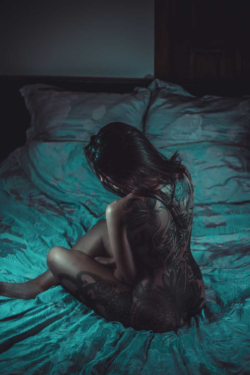 性感纹身的模特在床上