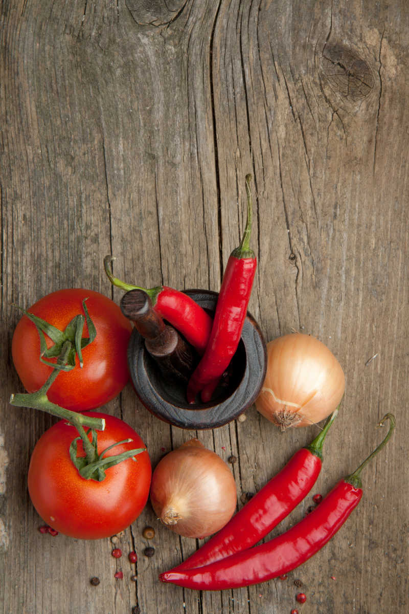 木桌上的辣椒与番茄等蔬菜