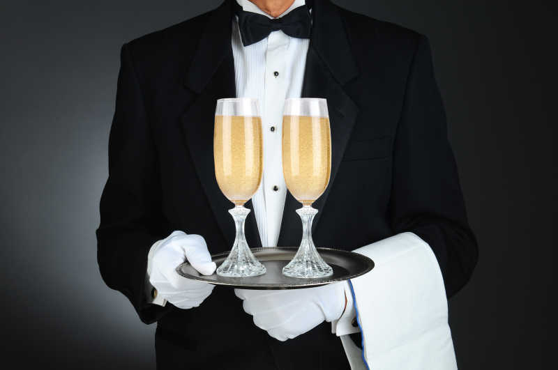 侍酒师端着的托盘上放着拿两只装满香槟的香槟酒杯