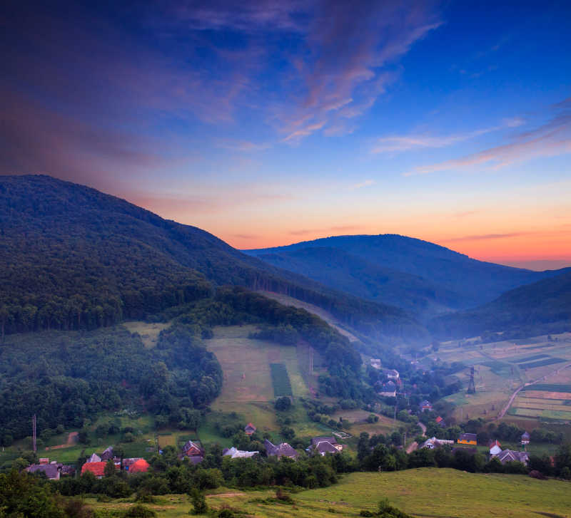 夕阳山坡上的村庄风景