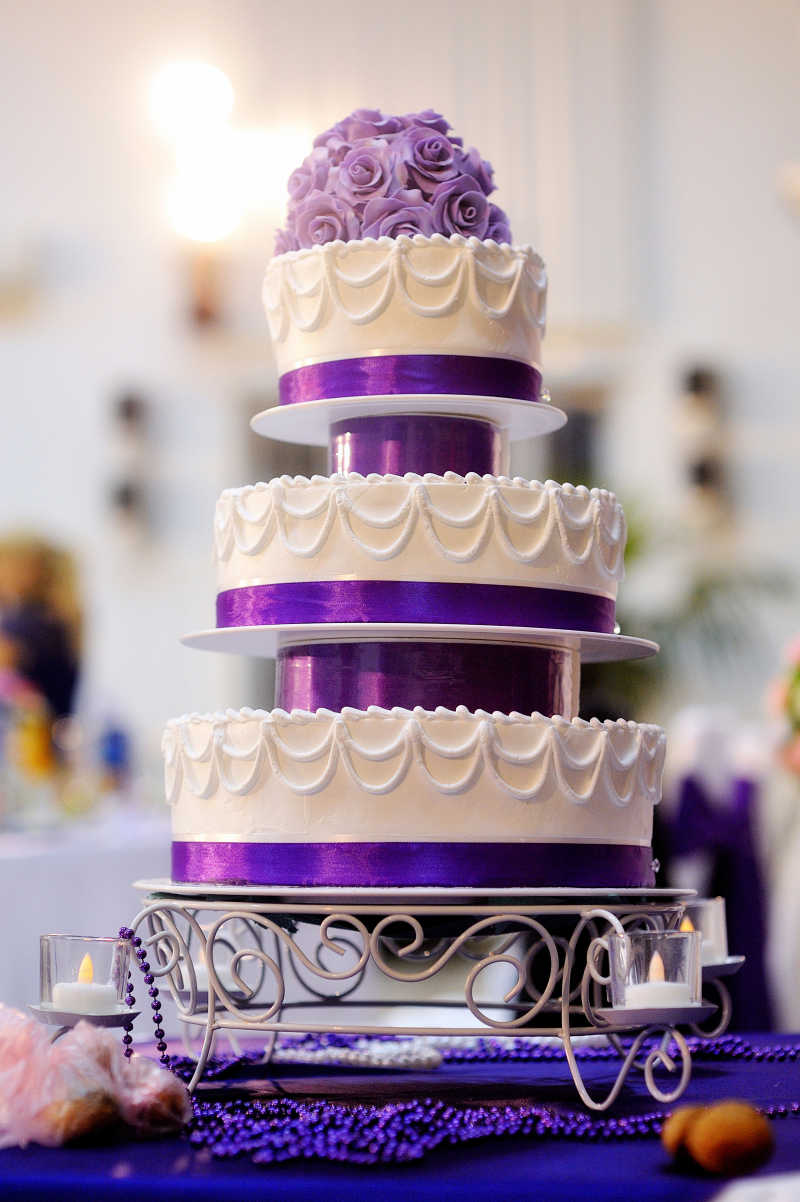 带有紫色花朵的白色婚礼蛋糕