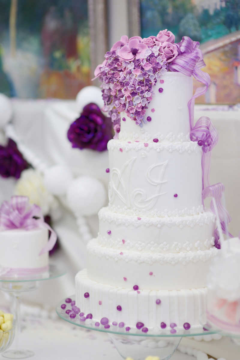 用紫色花朵装饰的白色婚礼蛋糕