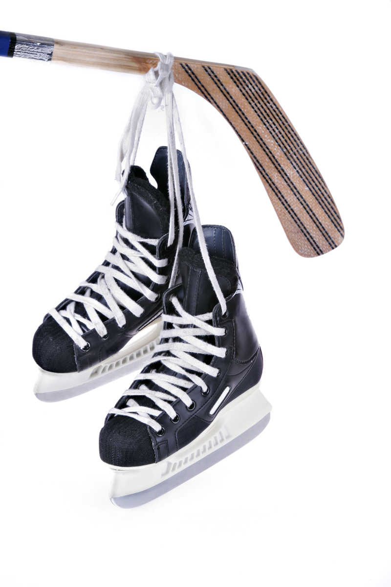 黑色溜冰鞋与曲棍球杆