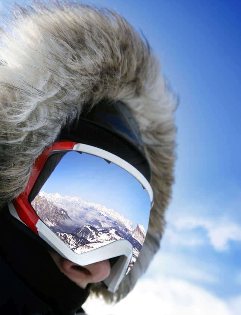 滑雪者戴着反射雪景的护目镜