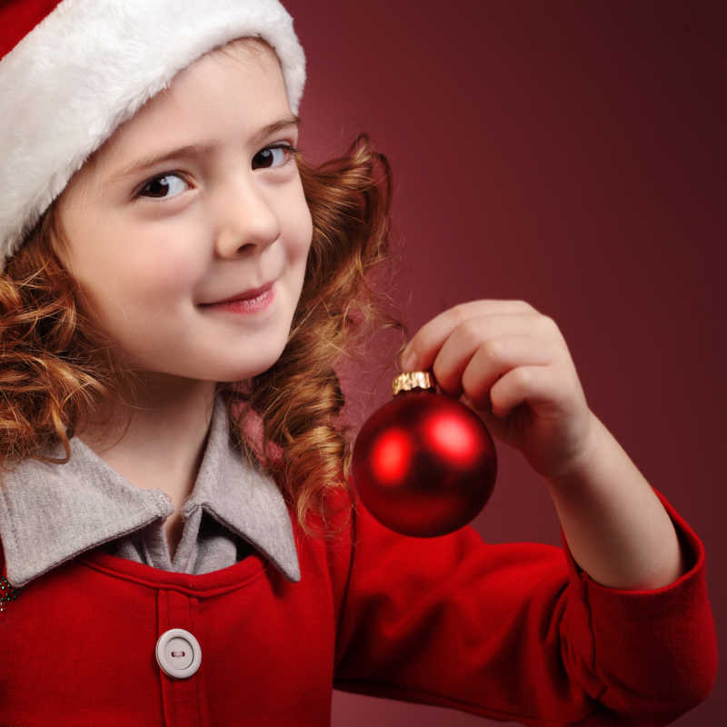红色圣诞装扮的小女孩手拿圣诞礼物