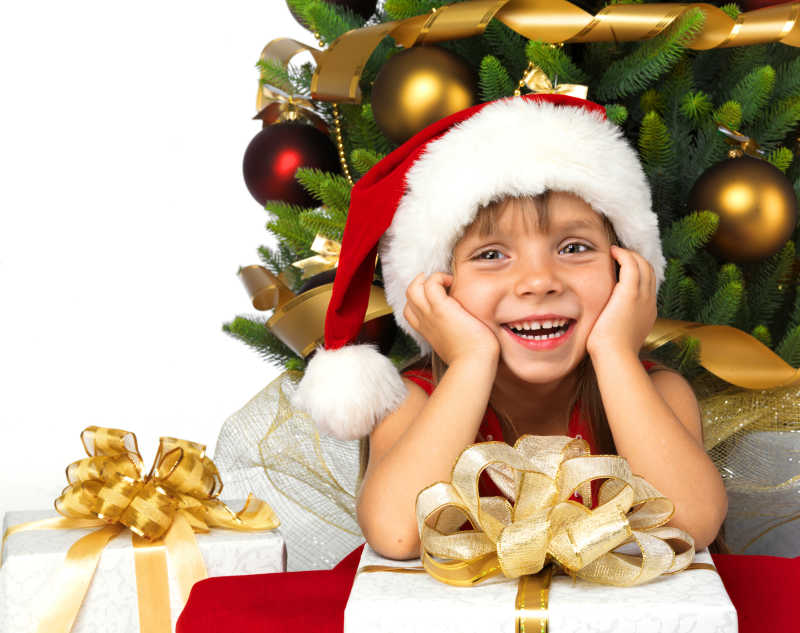 美丽的小女孩在圣诞树旁微笑着
