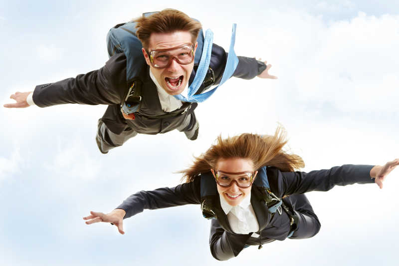 年轻商务伙伴在背上跳伞的概念形象