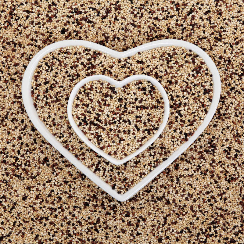 三色藜麦的超级食物在心形碗形成一个抽象的背景
