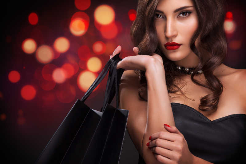 购物的女人拿着袋子在黑色星期五的圣诞假期的背景