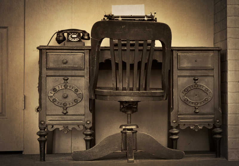 老式的装有旋转拨号电话的古董桌椅