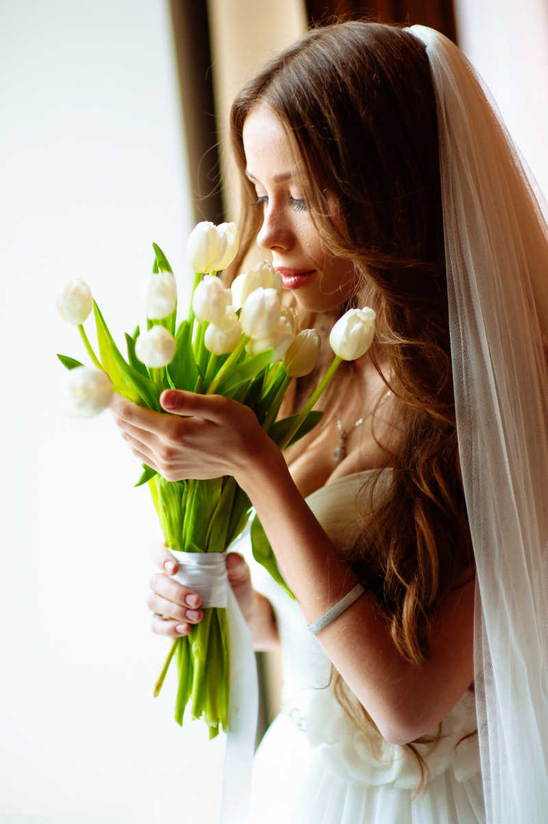 穿着婚纱的新娘手捧花束