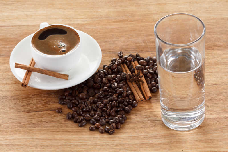 咖啡杯和豆肉桂枝大茴香放在木桌上