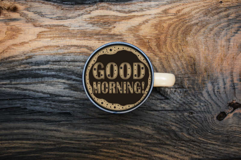 木色桌面上一杯咖啡带来的早晨问候概念
