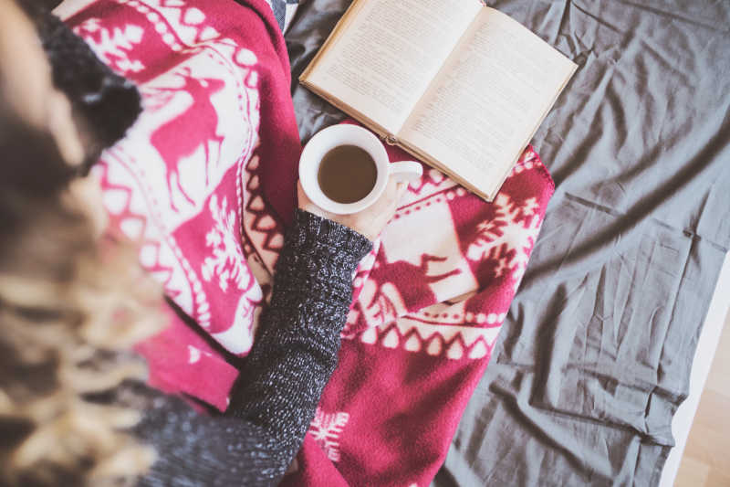 穿 粉色裙子的女人端着咖啡看书