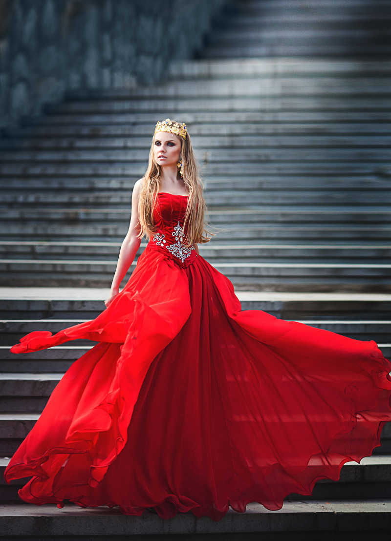 穿着红色连衣裙的美女站在楼梯上