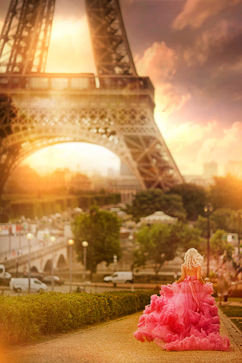 埃菲尔铁塔背景下奔跑的粉红连衣裙梦幻女孩