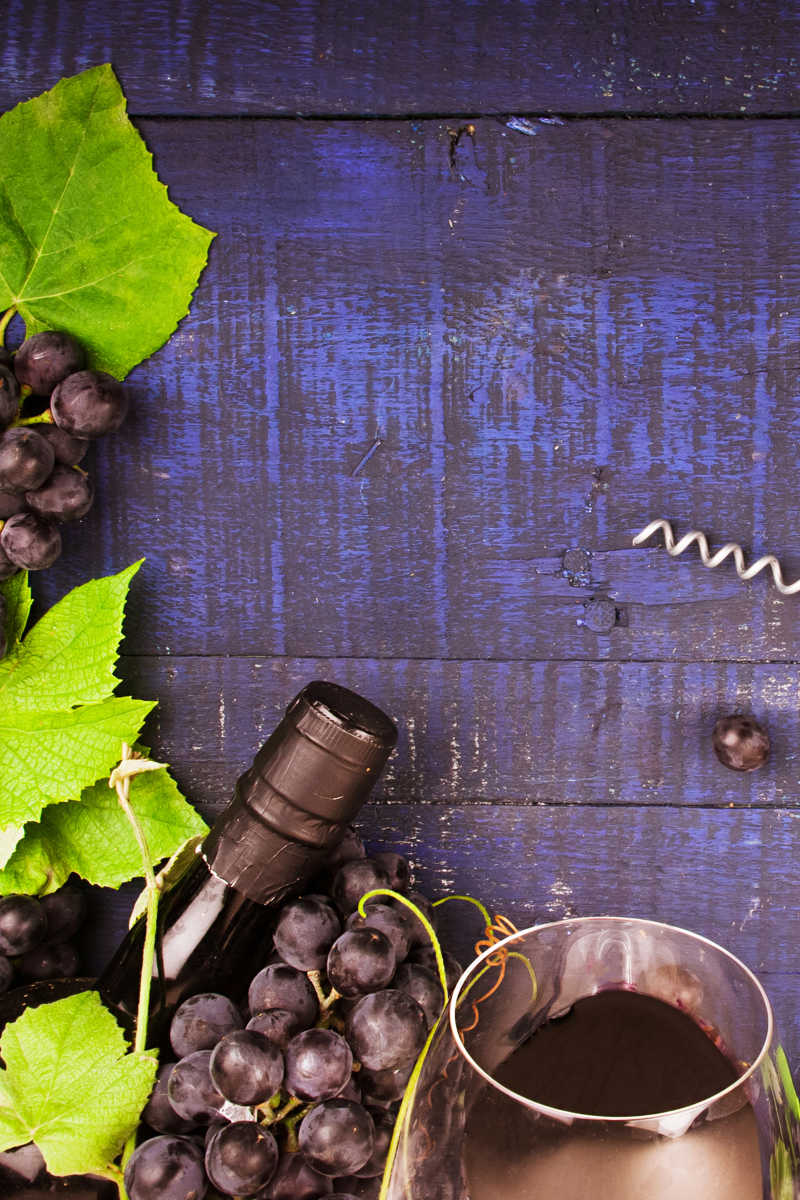 木制背景上的葡萄酒与葡萄