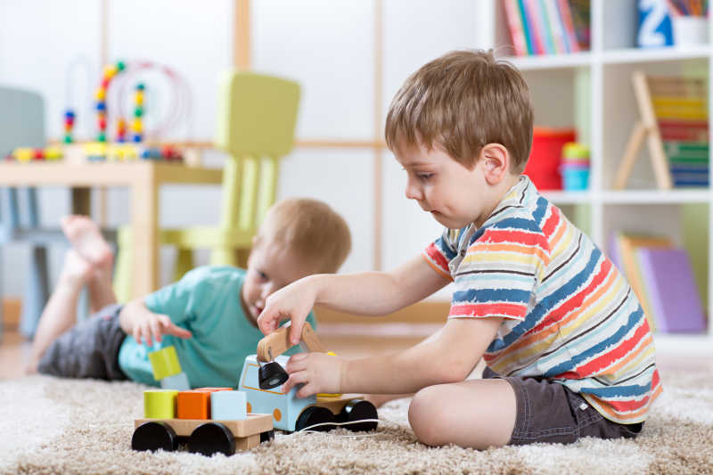 在幼儿园的室内玩积木火车的孩子