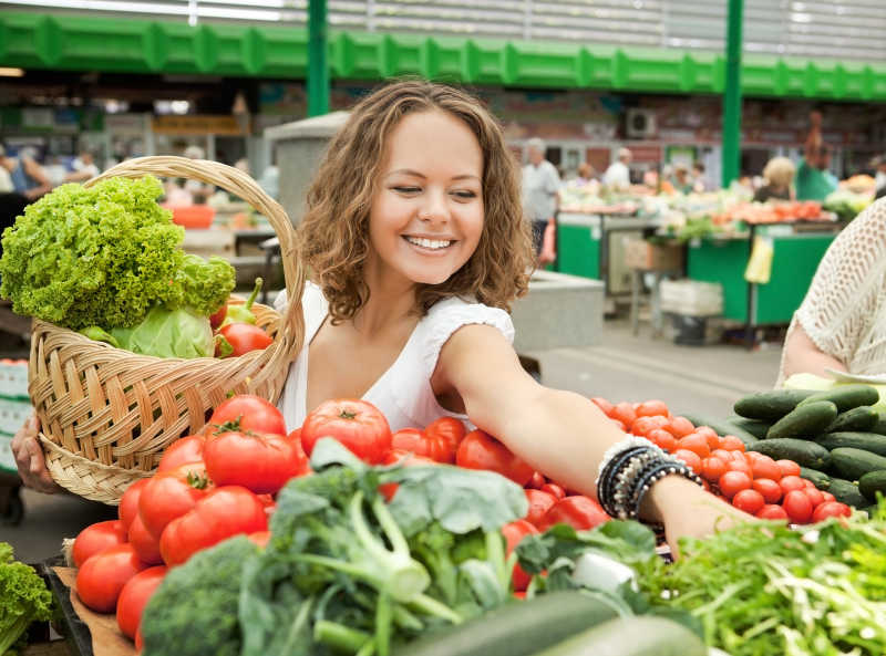 年轻妇女正在开心的挑选蔬菜