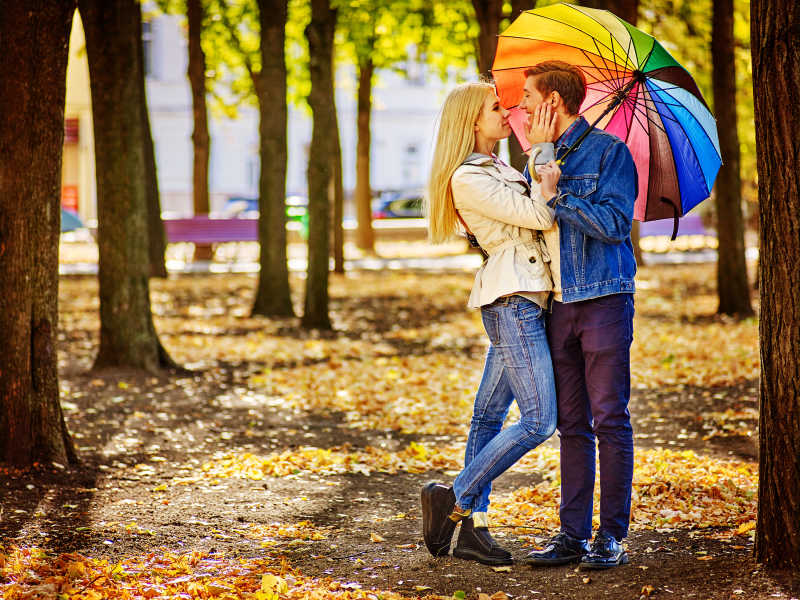 秋天公园小路上幸福的年轻夫妇