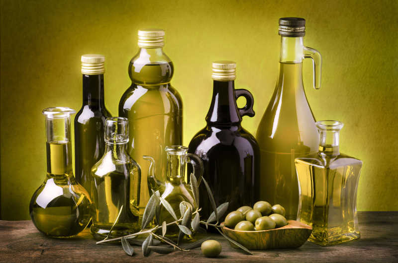 木质桌板上不同大小瓶状的橄榄油