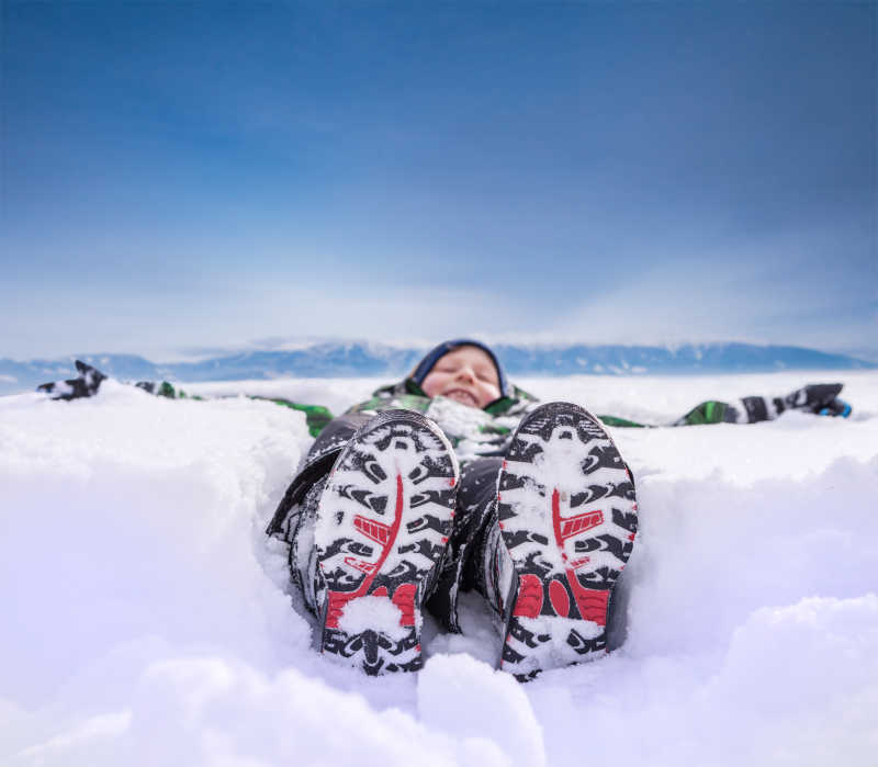 躺在山上的大雪中的男孩
