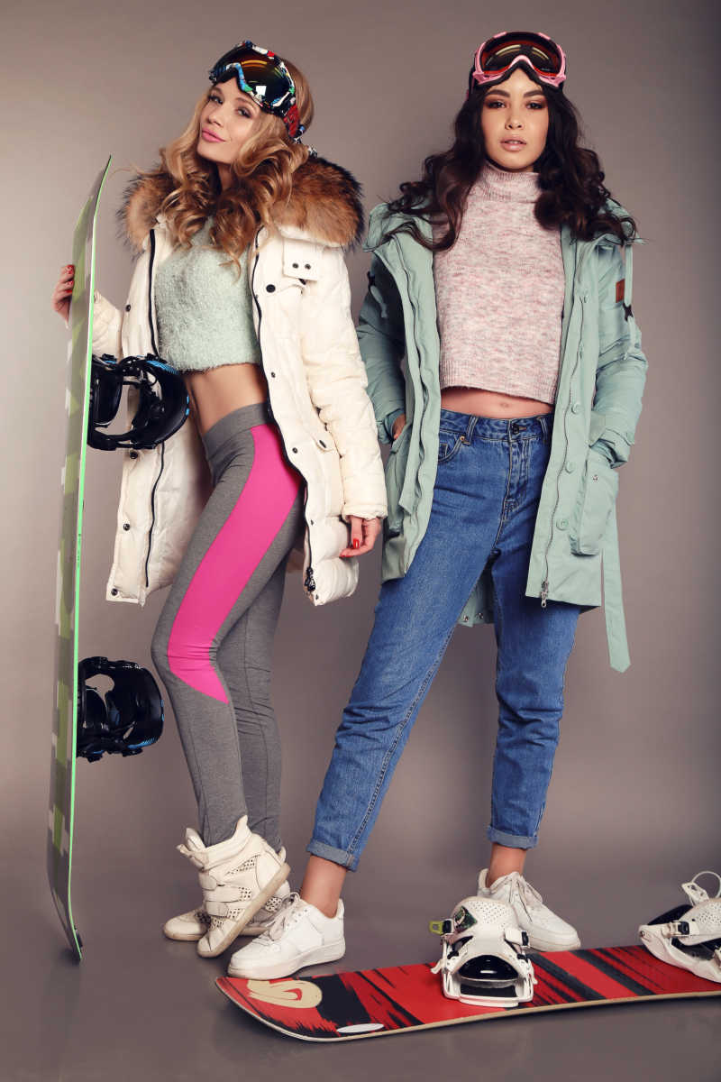 两个漂亮的滑雪女孩穿着滑雪设备