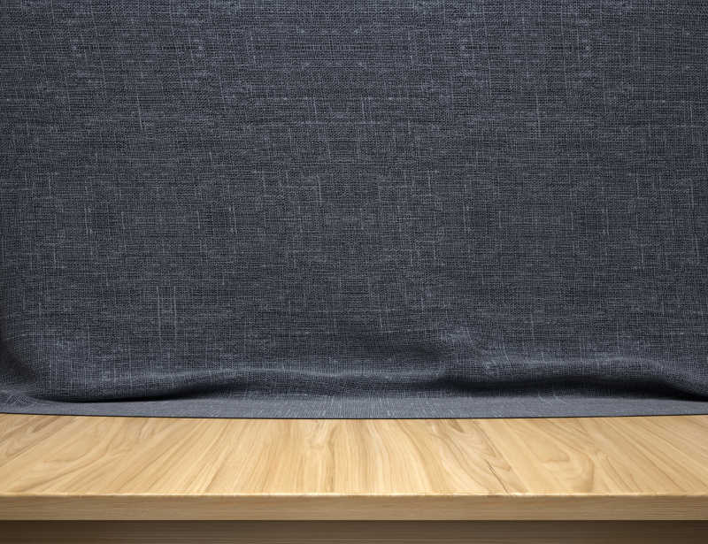 深蓝色棉织品背景前的木桌