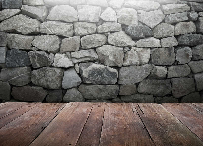 石墙背景中的木桌