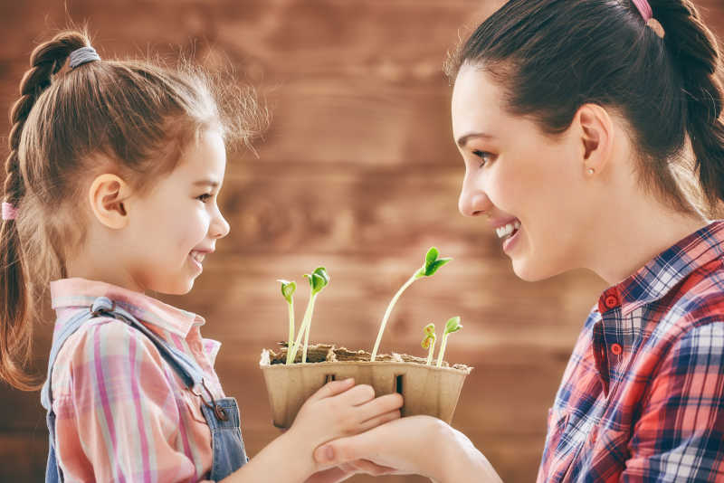 和妈妈一起照顾植物的小女孩
