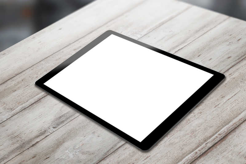 木桌上白色屏幕的平板电脑