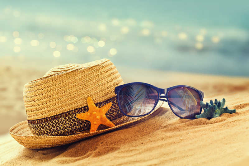 沙滩上的草帽与太阳眼镜