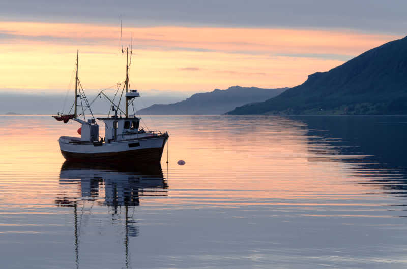 日落时分位于峡湾一艘渔船