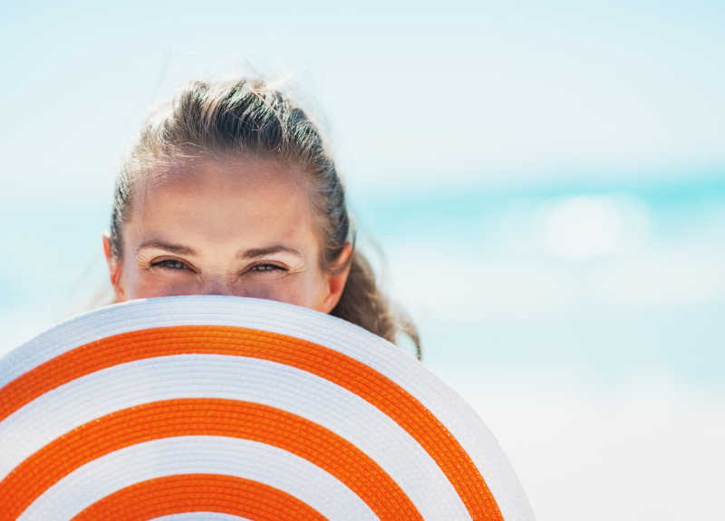 藏在沙滩帽后面的快乐女人