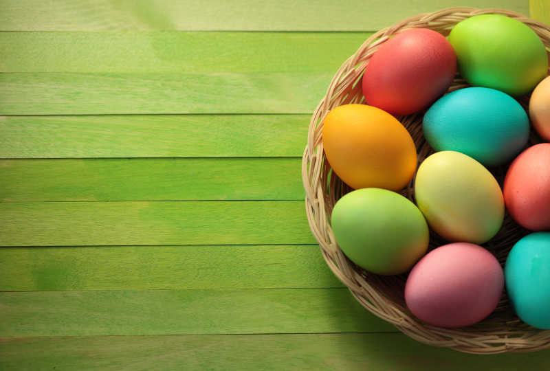 绿色桌上的彩绘复活节蛋篮