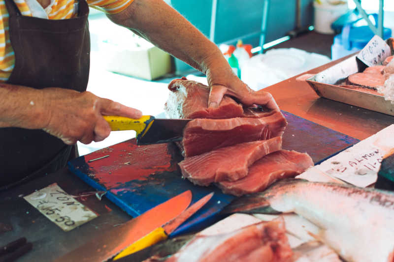 市场上切割鱼肉的摊主