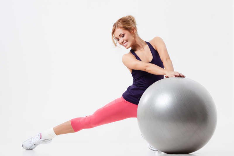 正在用瑜伽球做健身运动的女人