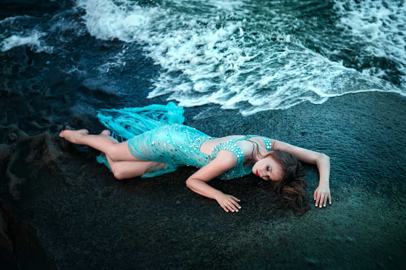 穿着长裙躺在海滩上的时髦女人