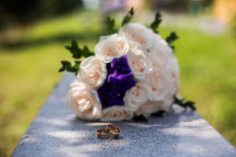 结婚戒指在白色和粉红色花束中间