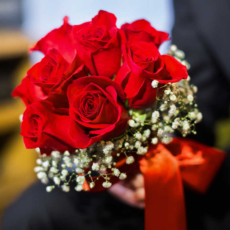 新郎手举婚礼花束红玫瑰