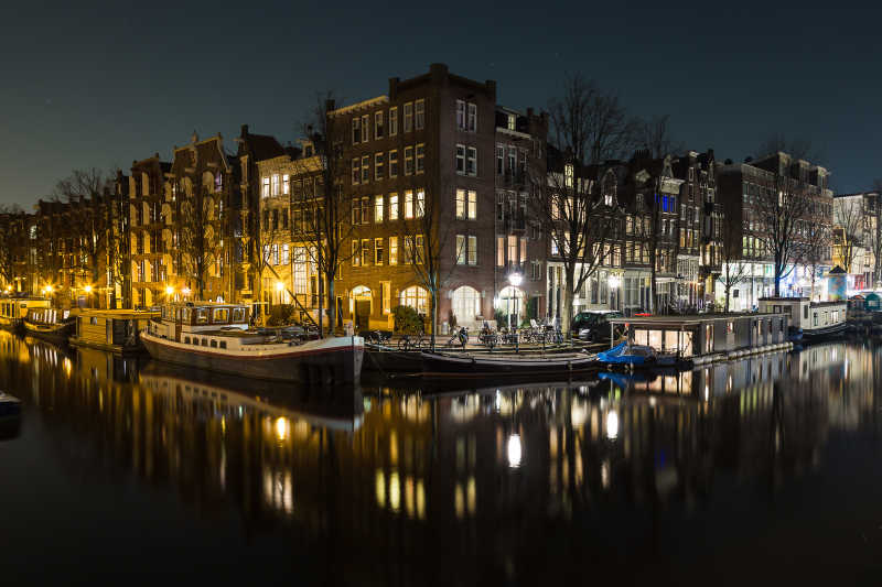 黑色夜空下运河旁阿姆斯特丹建筑的夜晚