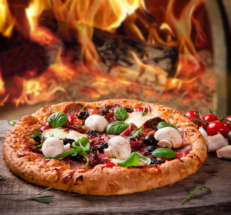 火焰背景下美味的蘑菇披萨饼