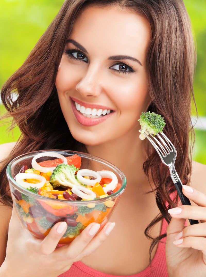 黑发女人吃素食蔬菜沙拉