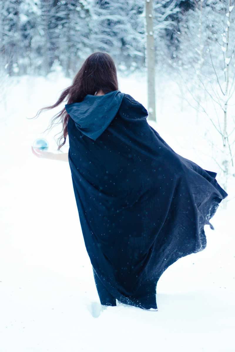 雪地里披着蓝斗篷的美女