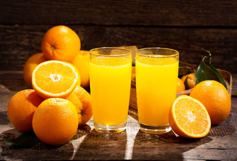 木制桌上两杯鲜榨橙汁