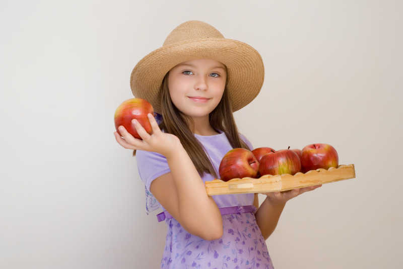 戴帽子拿苹果的女孩
