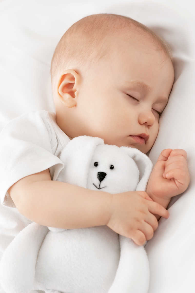 抱着毛绒玩具睡觉的婴儿