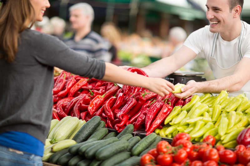 妇女在街头市场购买新鲜有机蔬菜